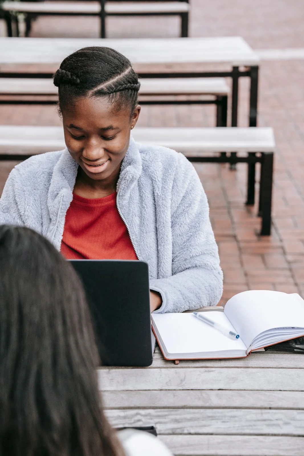 Black student working on a laptop outdoors
